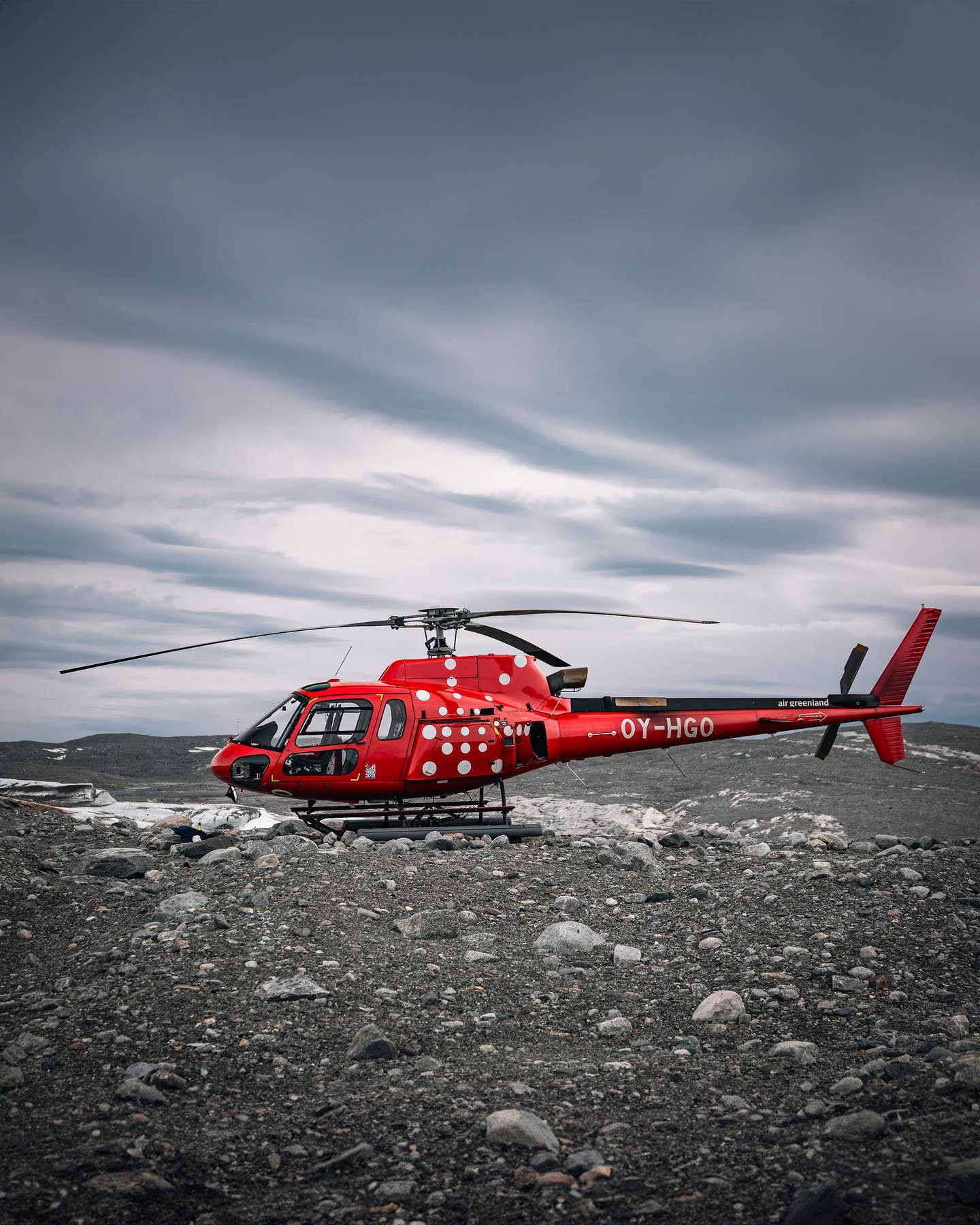 The red colour of @airgreenland really pops in the barren landscape at the very edge of Sermeq Kujalleq. There and back on the not that young but - we were told - trusty @airbus #as350 #canoneosr6markii #eosr6markii #sigma24105art @worldofgreenland